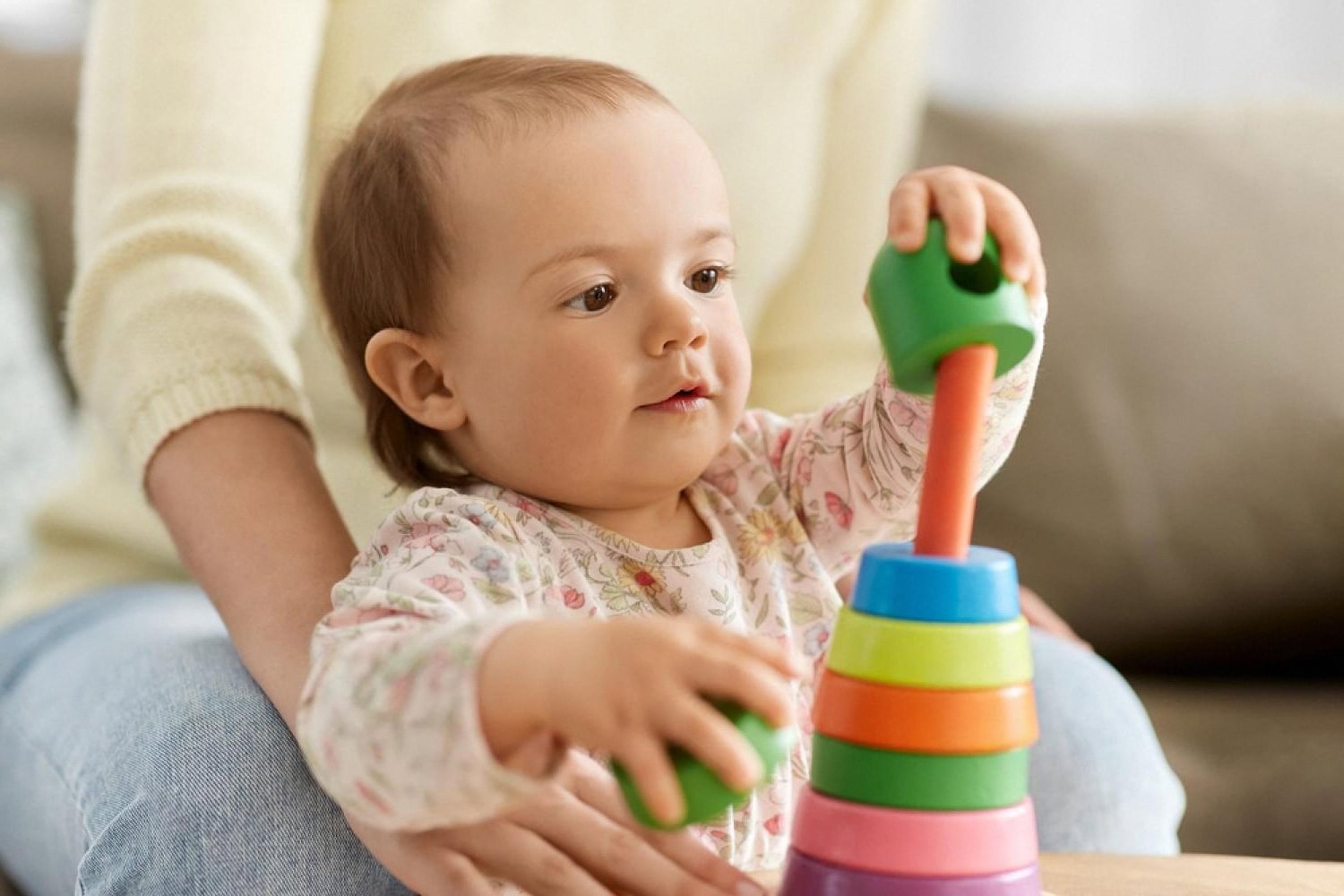 Toddler stacking colourful rings during open-ended play at home in the UAE