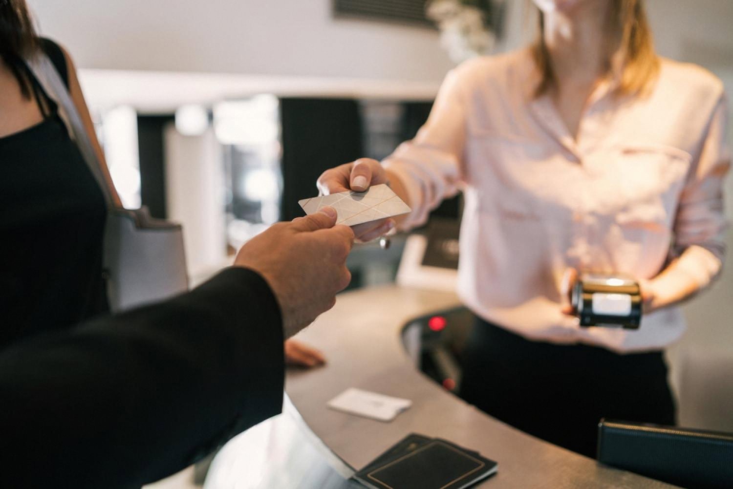 Guest handing an ID card to a hotel receptionist during check-in at a UAE hotel