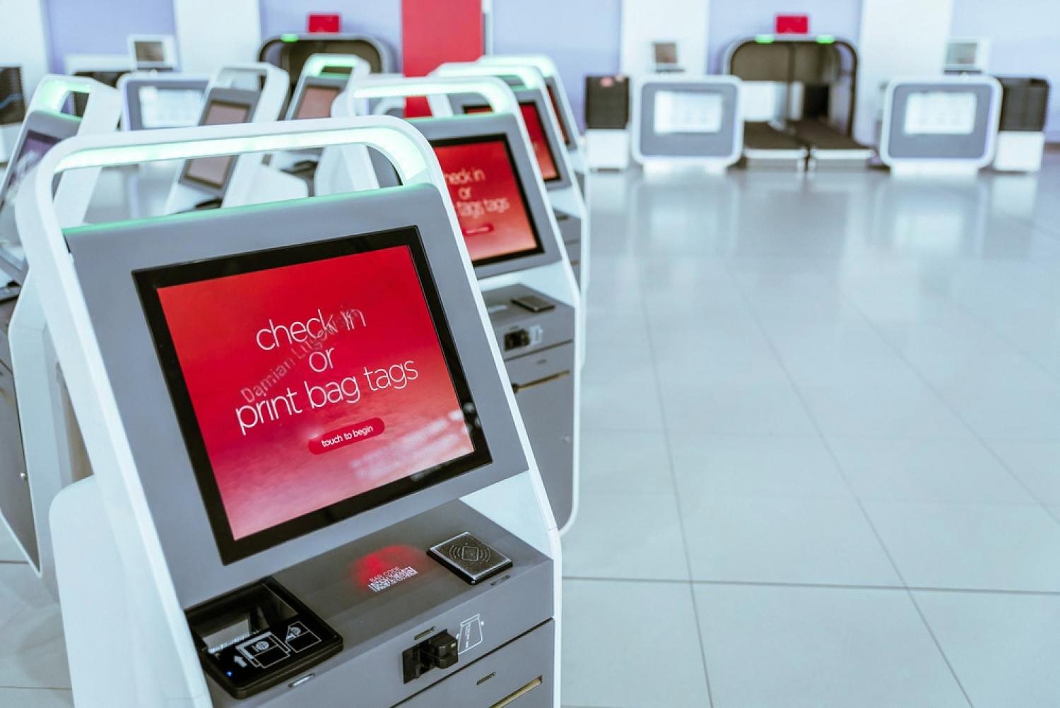 Self-service check-in kiosks with built-in document scanners in an airport-style terminal